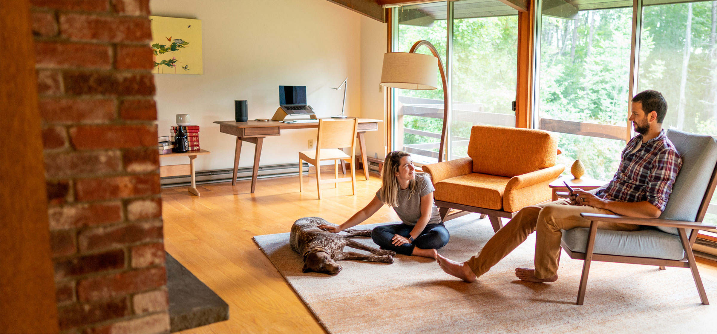 young couple with their hound dog hanging out in a modern living room