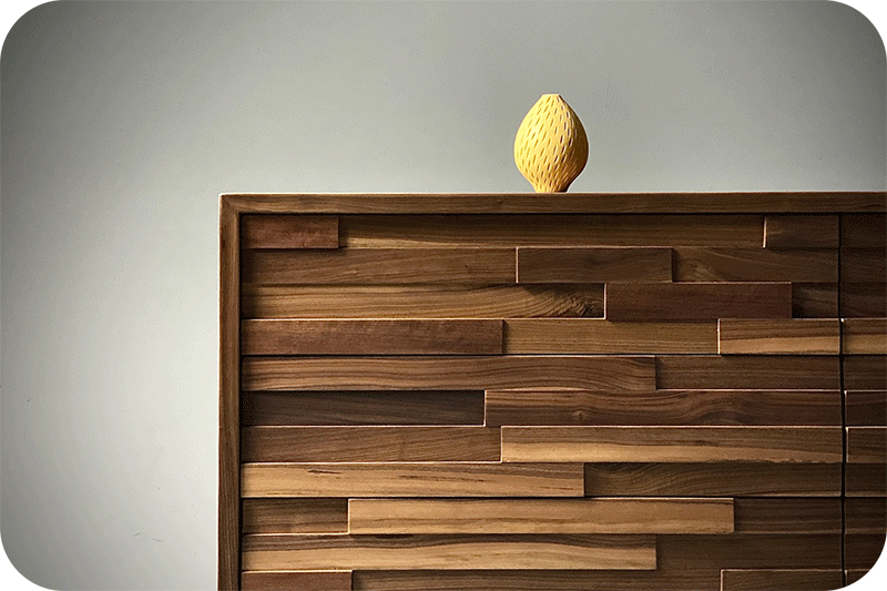 close up of textured wood front dresser with lemon sculpture on top