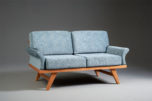 light blue couch with cherry wood base and legs