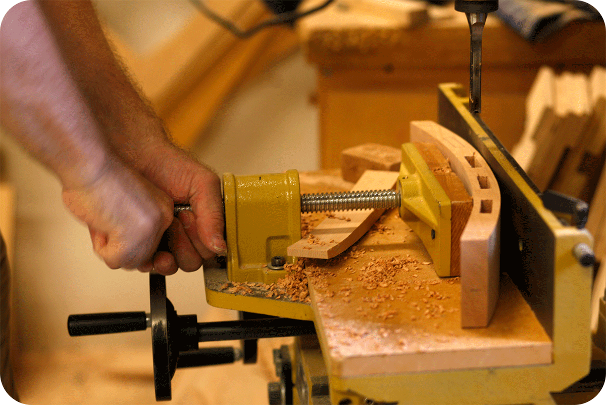 a man's hands turning a vice